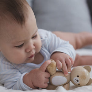 baby playing with plantoys wooden bear toy